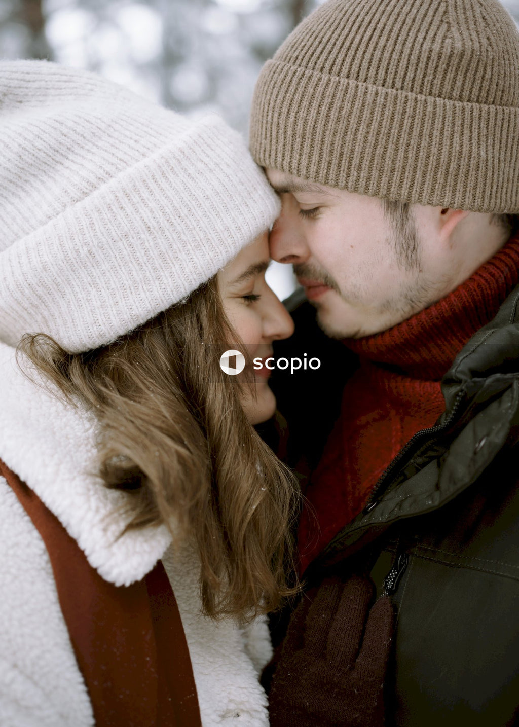 Man and woman in knit cap hugging each other