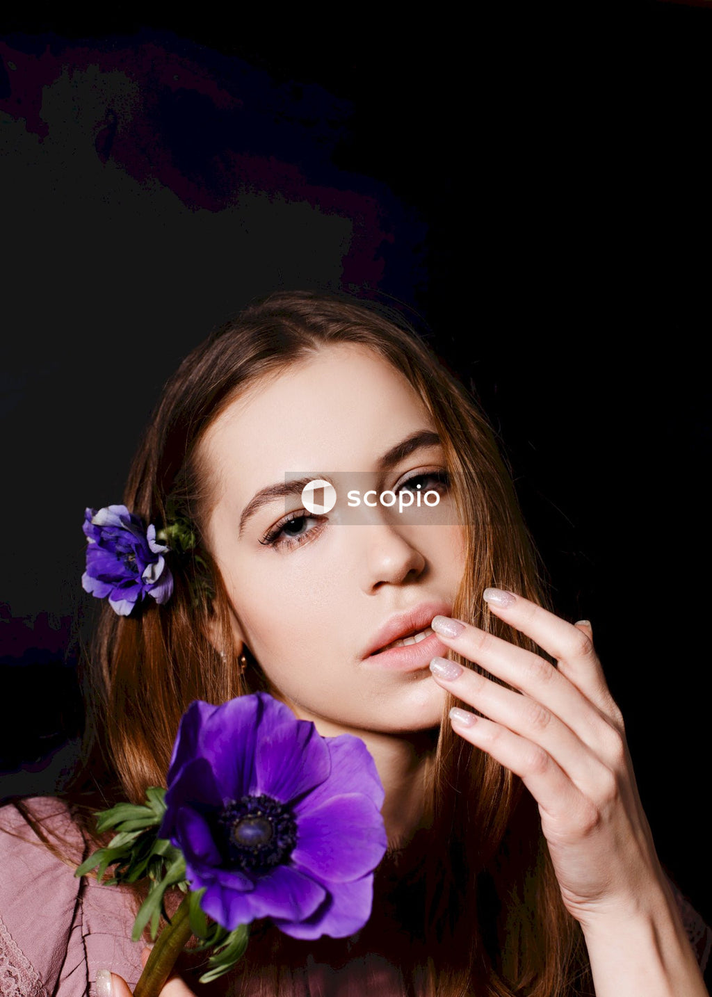 Woman in green shirt with purple flower on ear