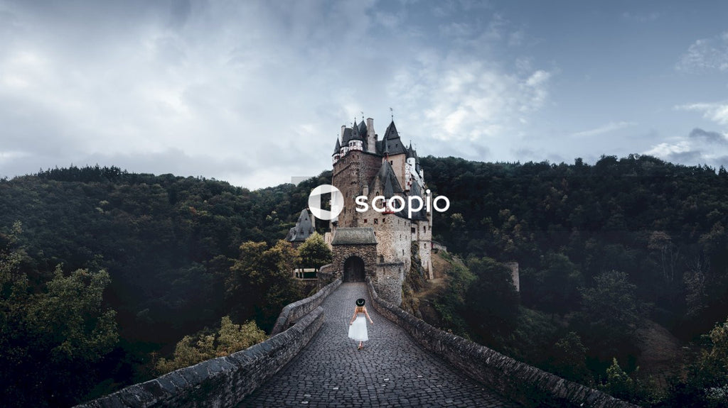 Woman in light dress walking towards Eltz Castle