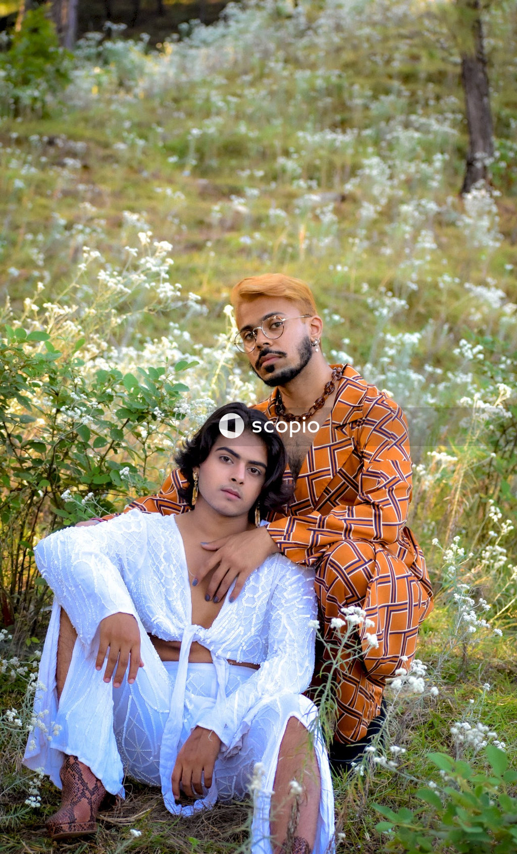 Two genderqueer man in stylish outfits having romantic moments outdoor in the nature
