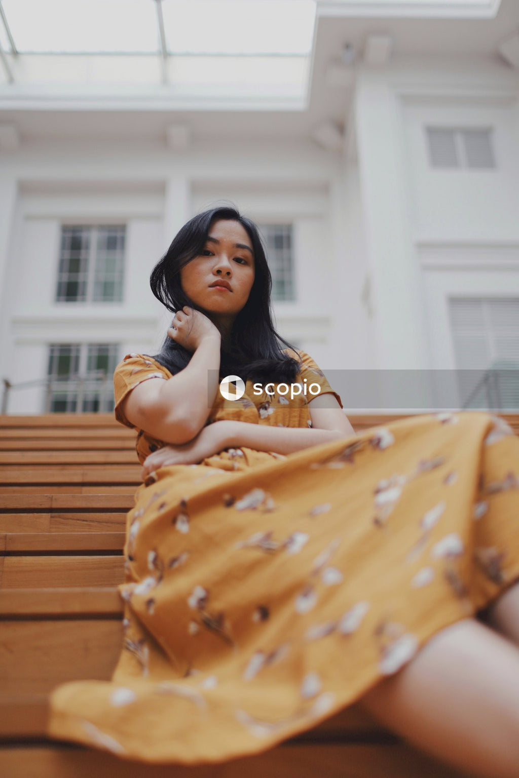 Woman in orange dress sitting on stairs