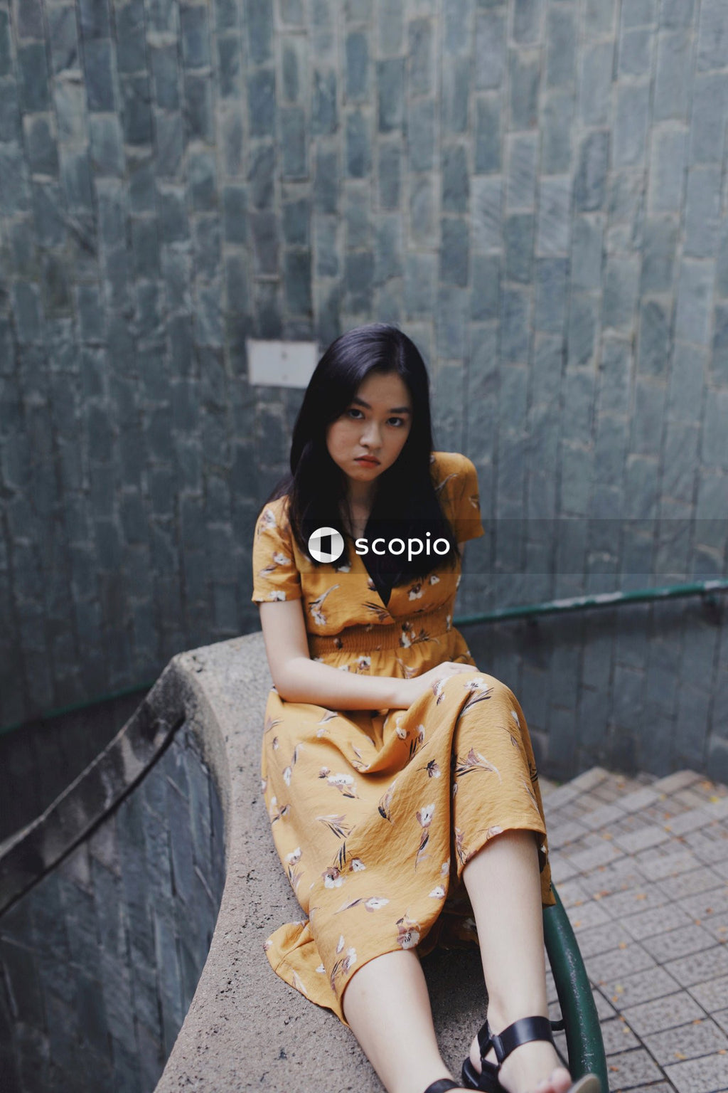 Woman in orange dress sitting on stairs