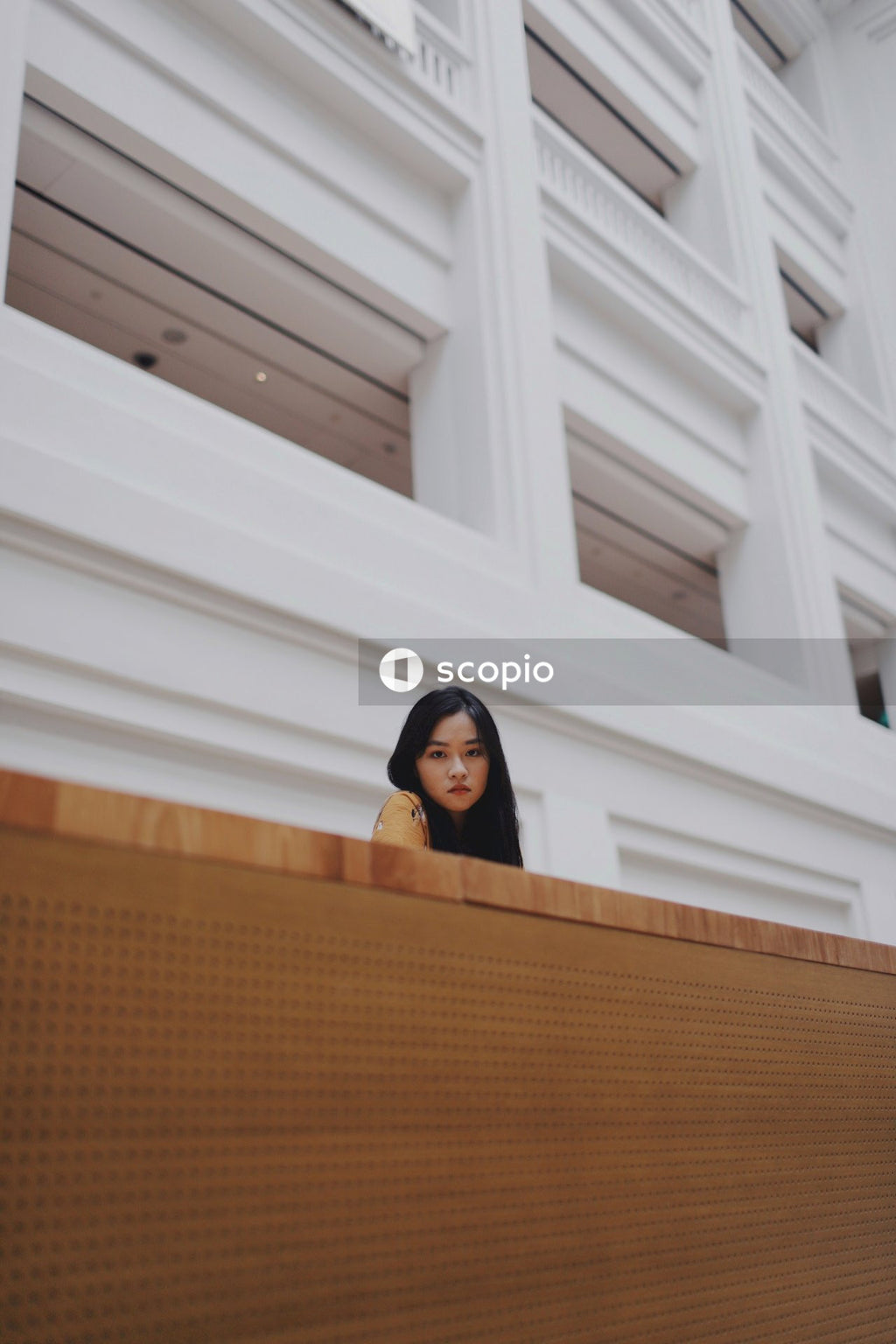 Woman in orange dress standing on balcony