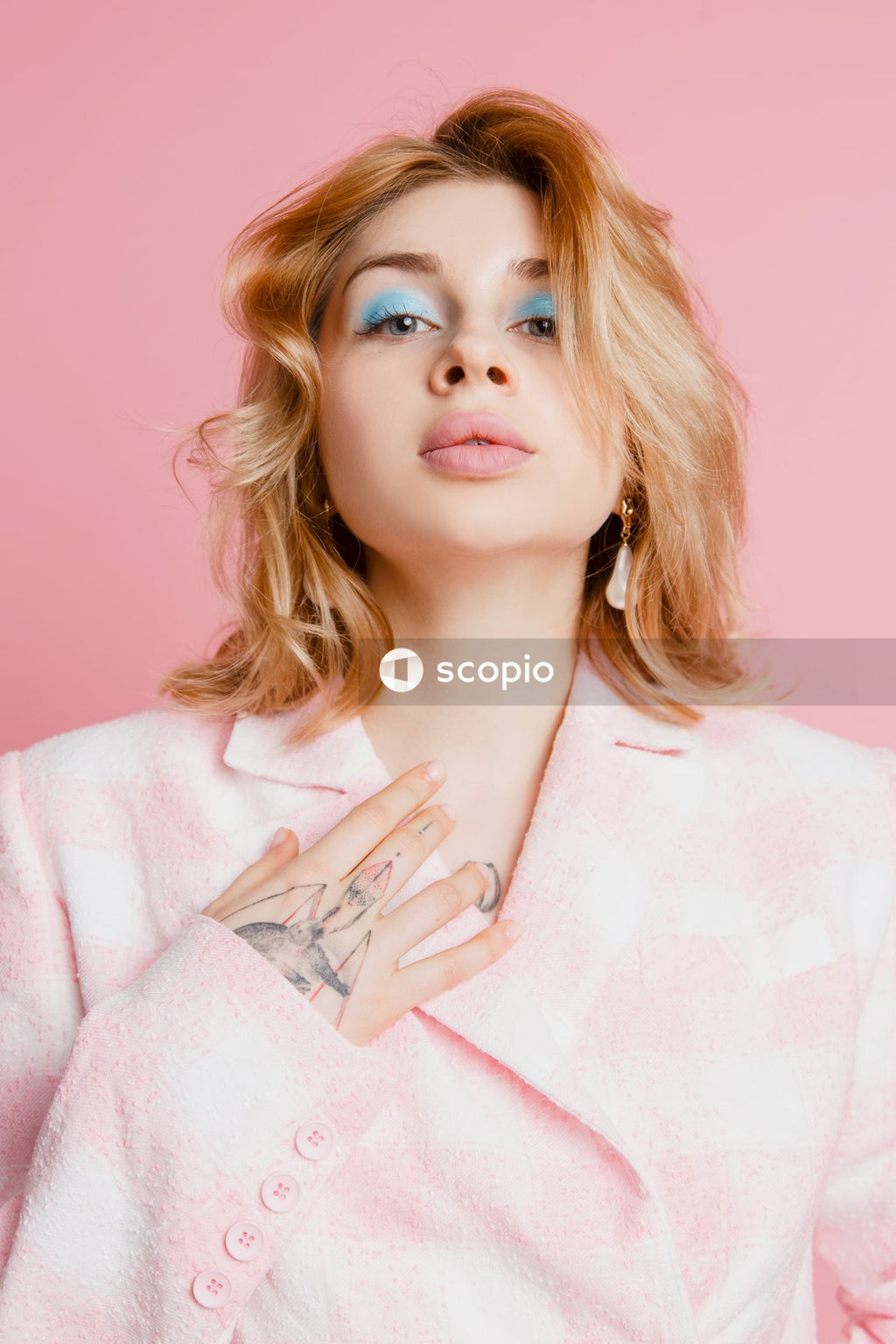 Woman in pink robe with hand on chin