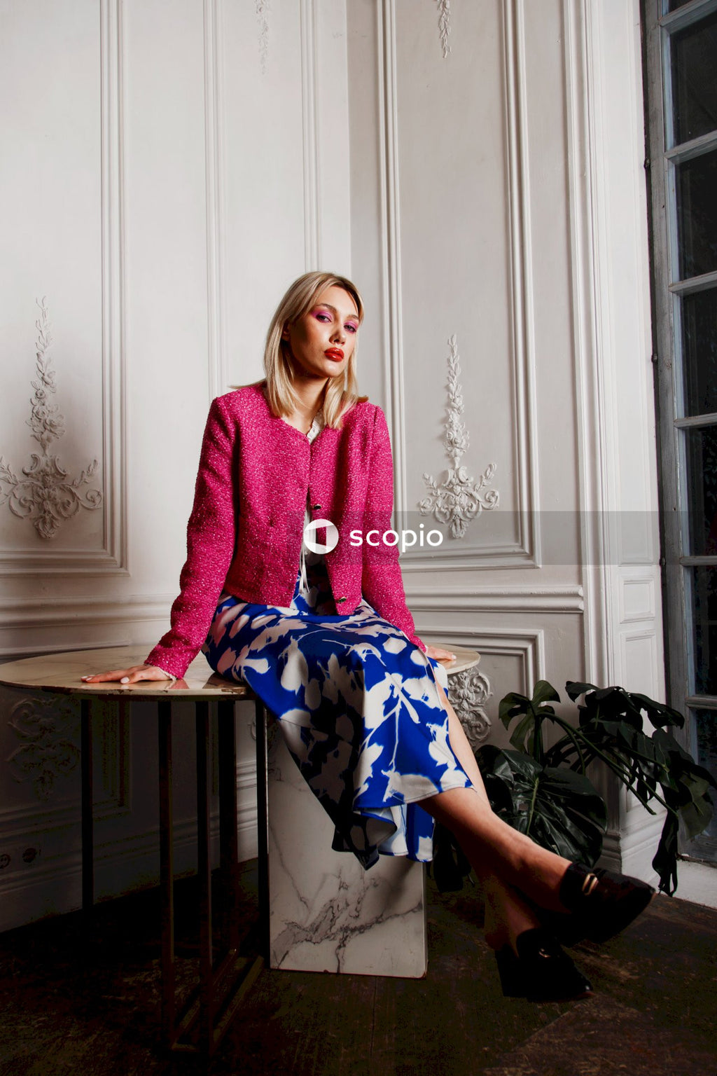 Woman in pink sweater sitting on white wooden door