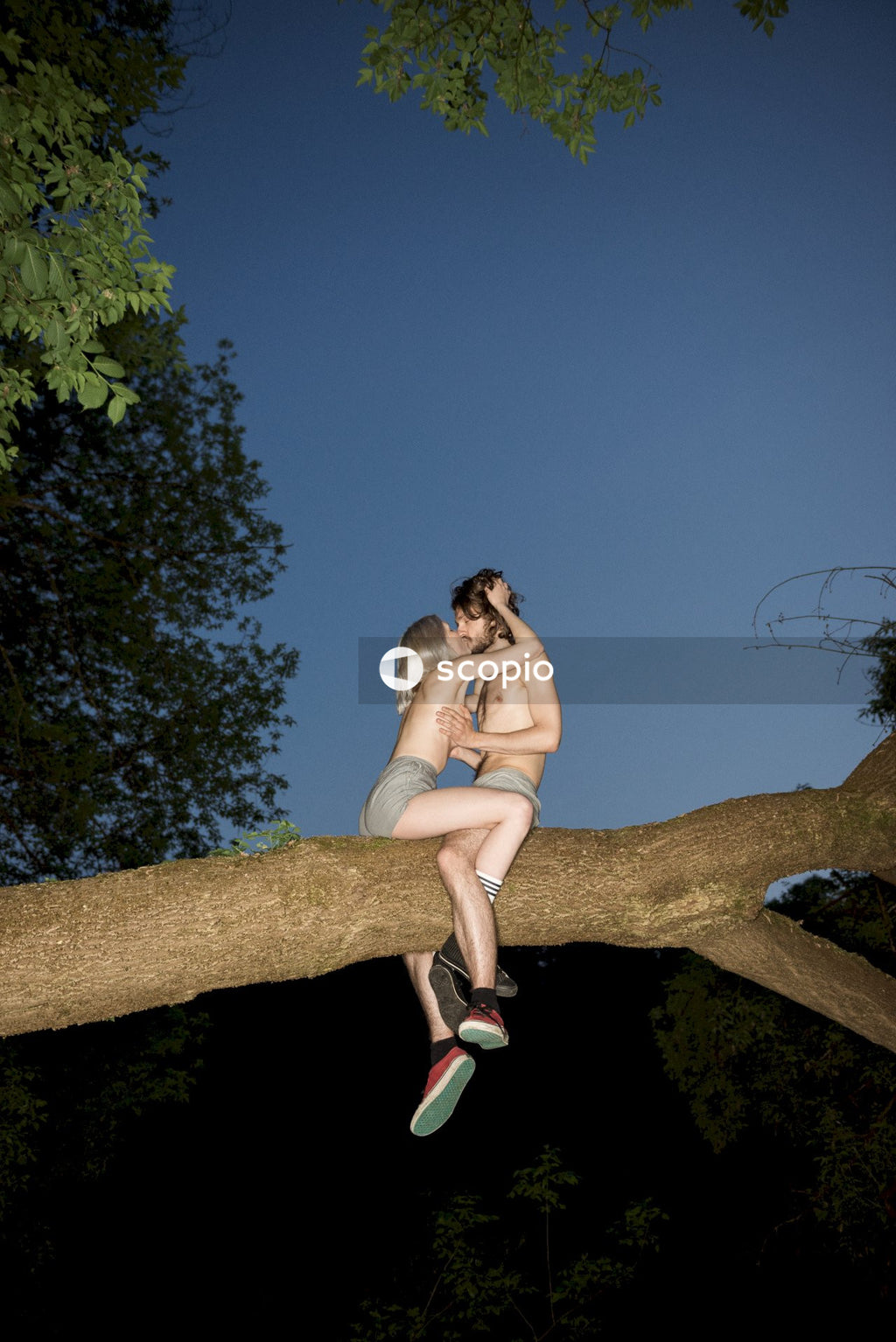 Man and woman kissing on tree