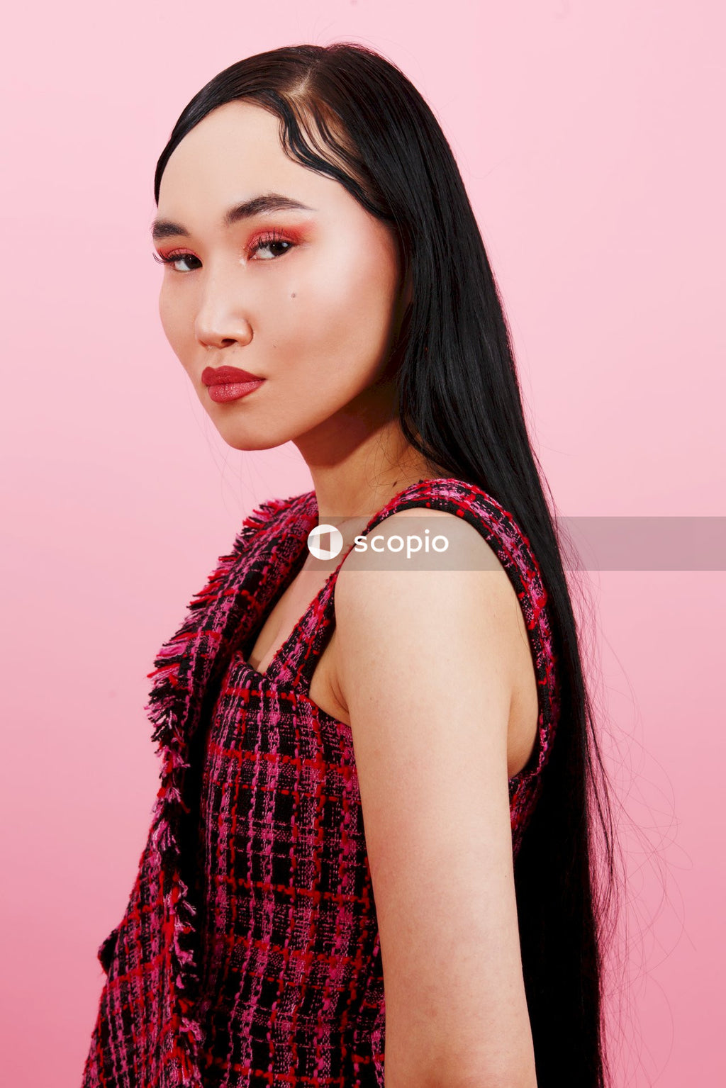 Woman in red and black plaid sleeveless shirt