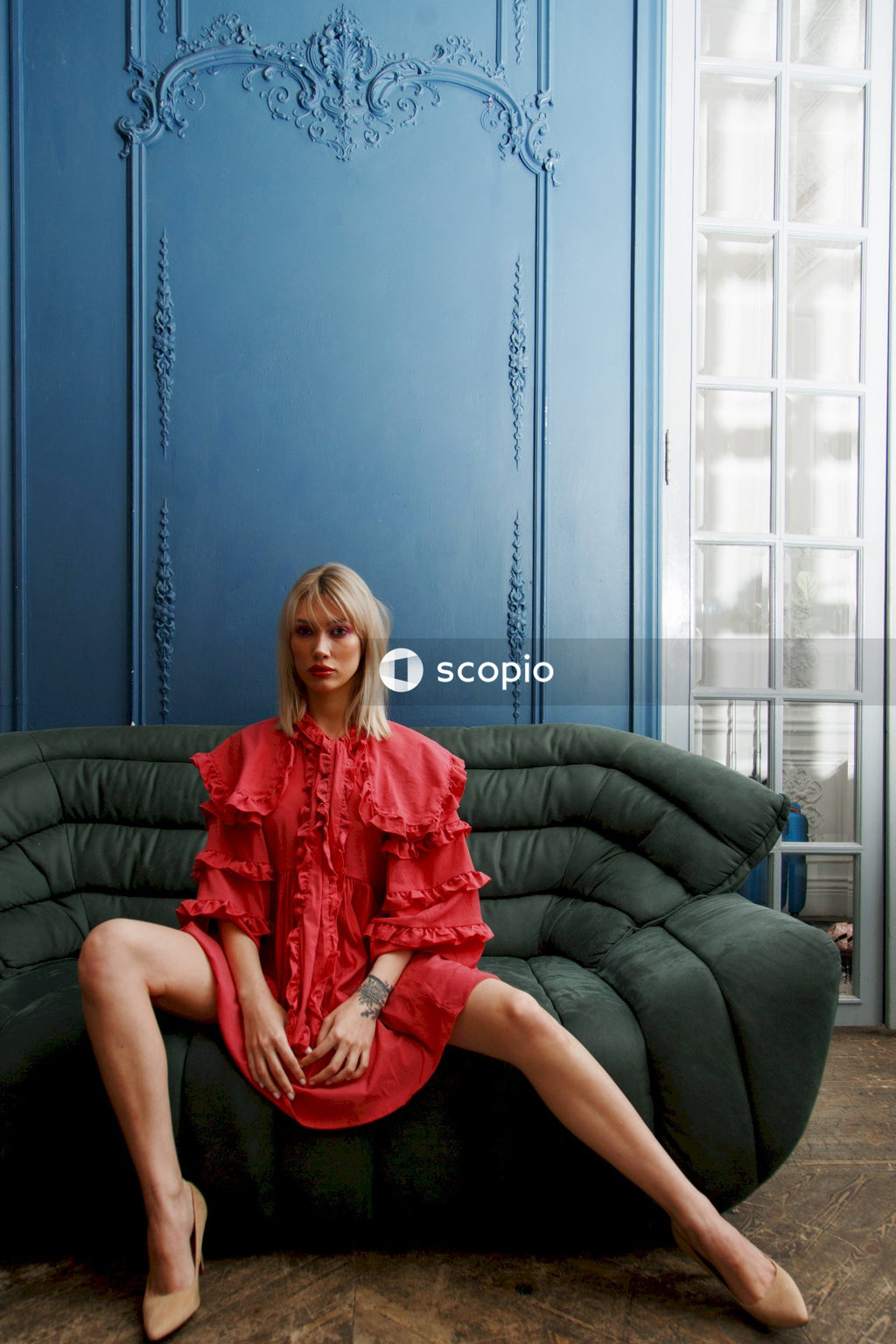 Woman in red and white dress sitting on black couch