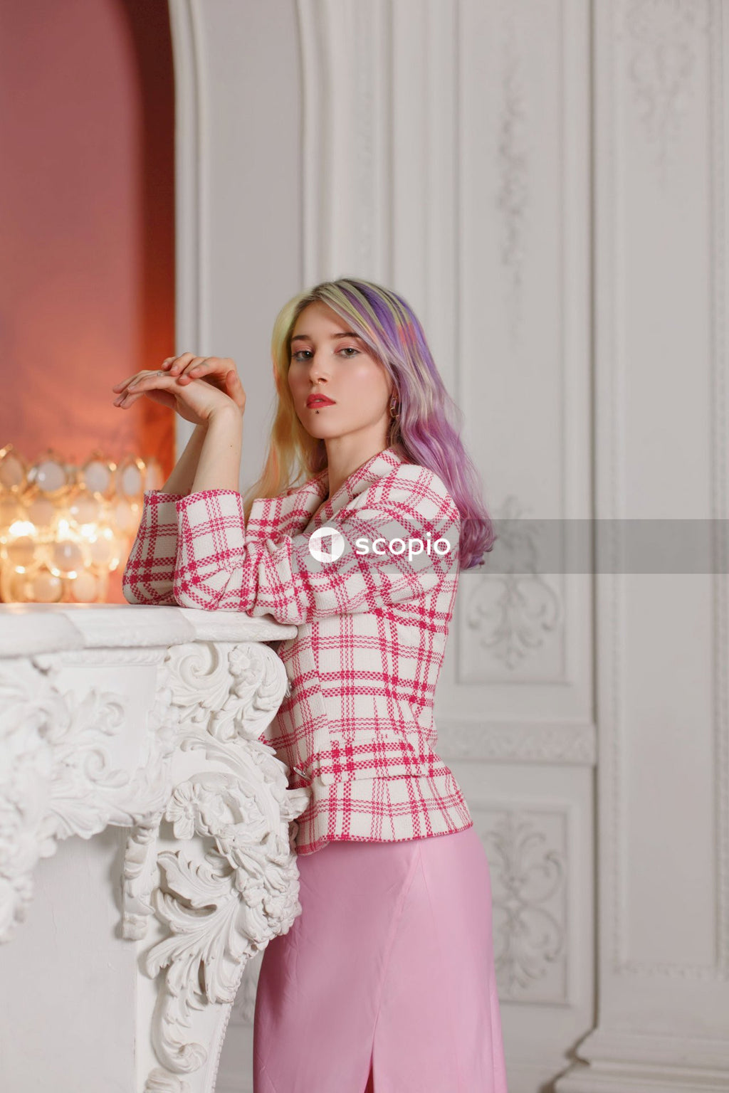 Woman in red and white plaid dress shirt sitting on white floral chair