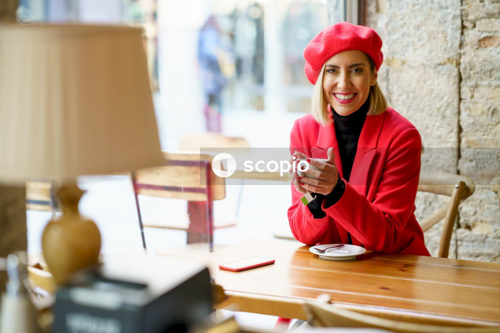 Woman in red hijab and red long sleeve shirt sitting on chair