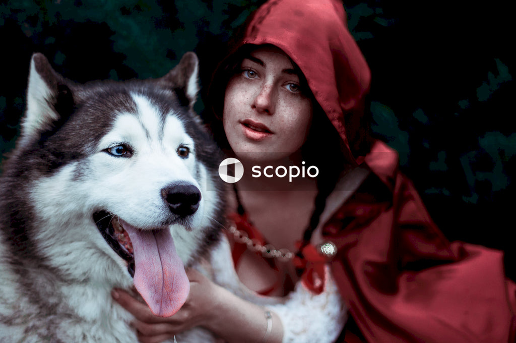 Woman in red hoodie hugging white and black siberian husky