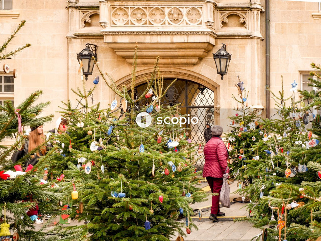Woman in red jacket standing near green plants