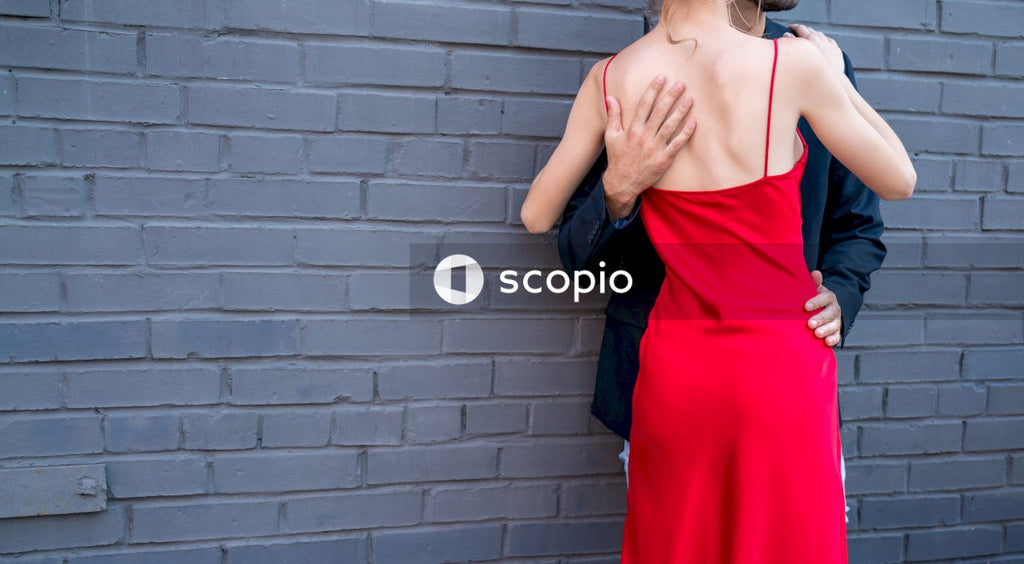 The guy hugs the girl in the red dress. Romantic date.