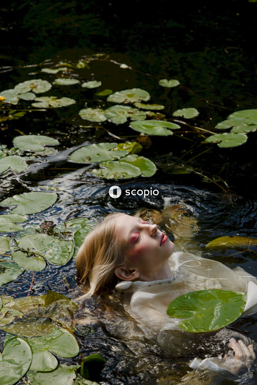 Woman in water with green leaves