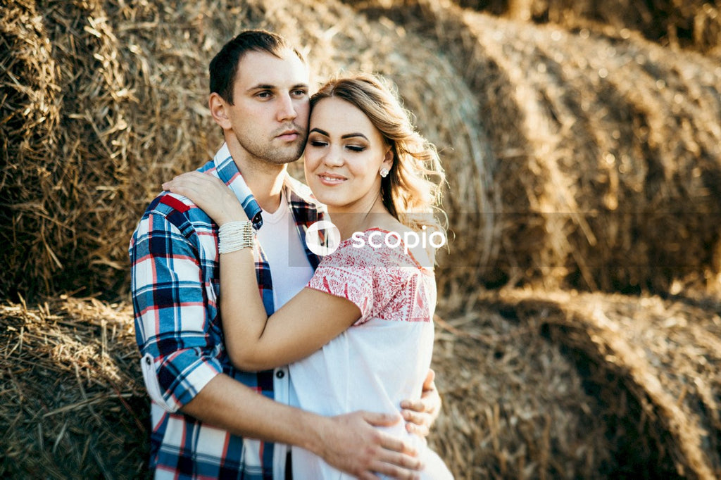 Woman in white and pink shirt hugging man in blue and white plaid button up shirt