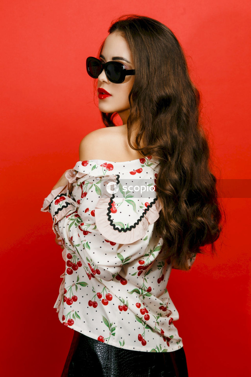 Woman in white and red floral dress wearing black sunglasses