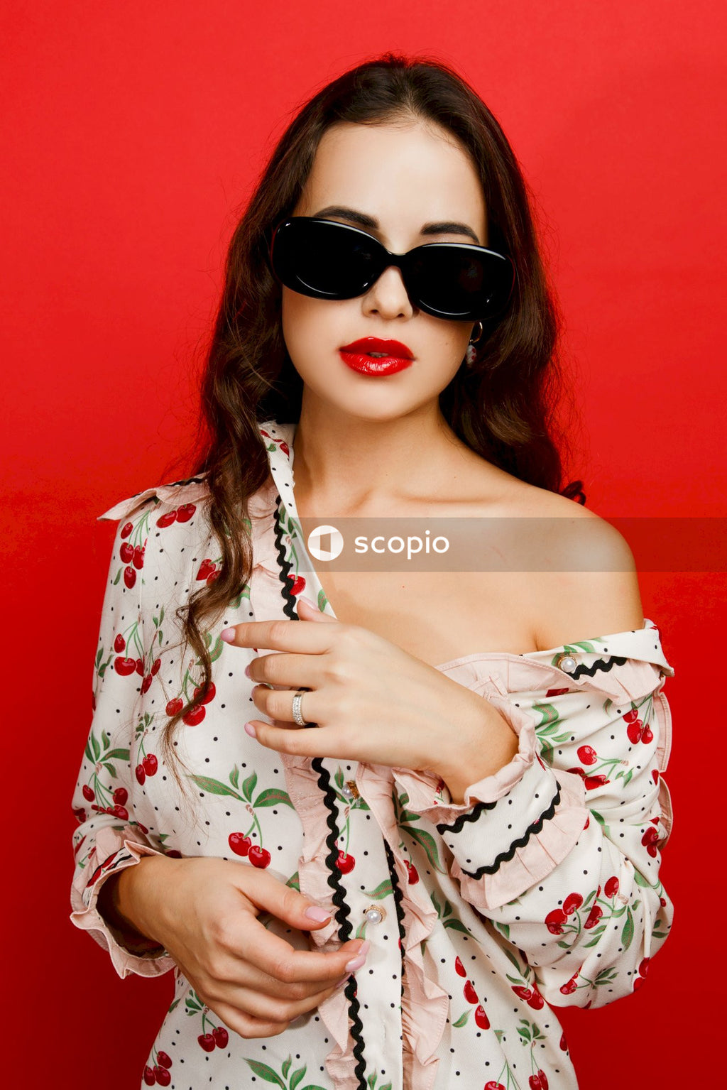Woman in white and red floral off shoulder dress wearing black sunglasses