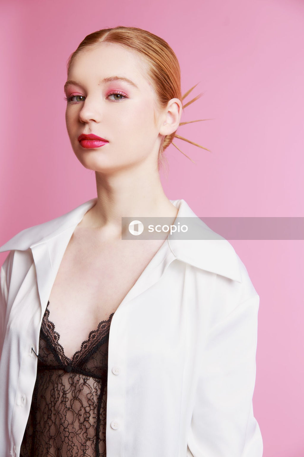 Woman in white blazer with red background