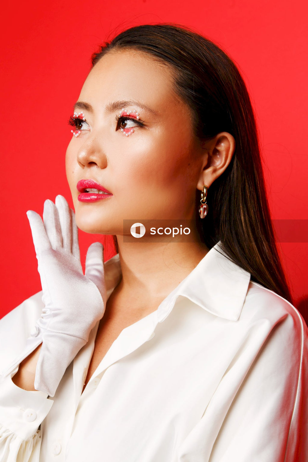 Woman in white button up shirt wearing silver earrings