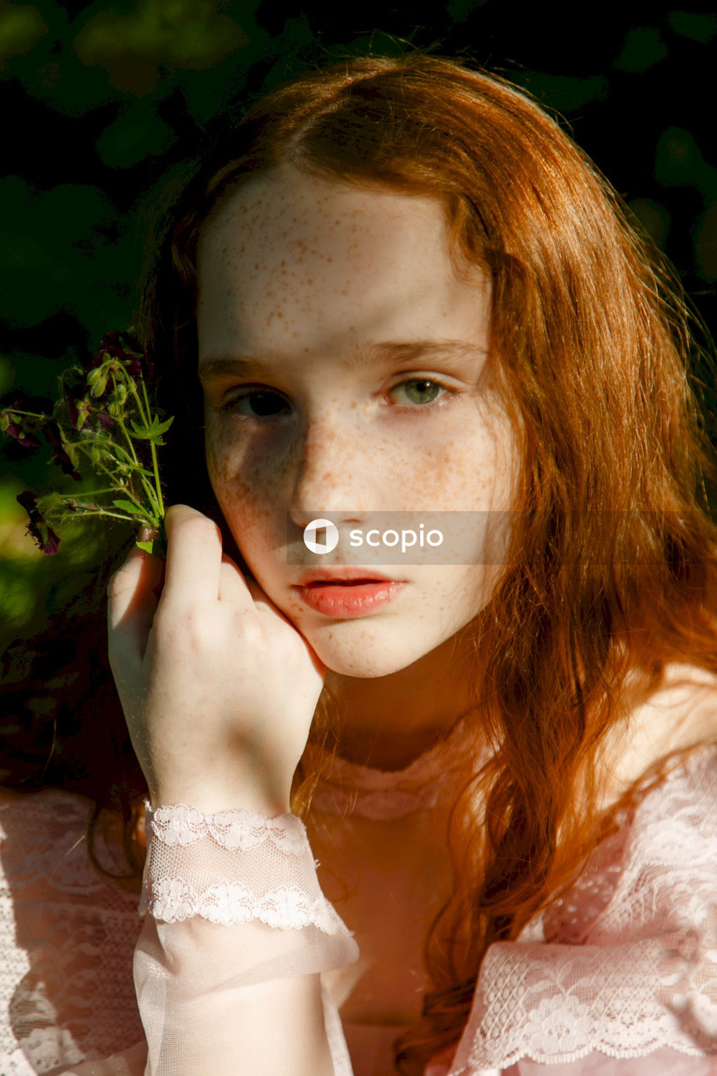 Woman in white dress holding green leaves