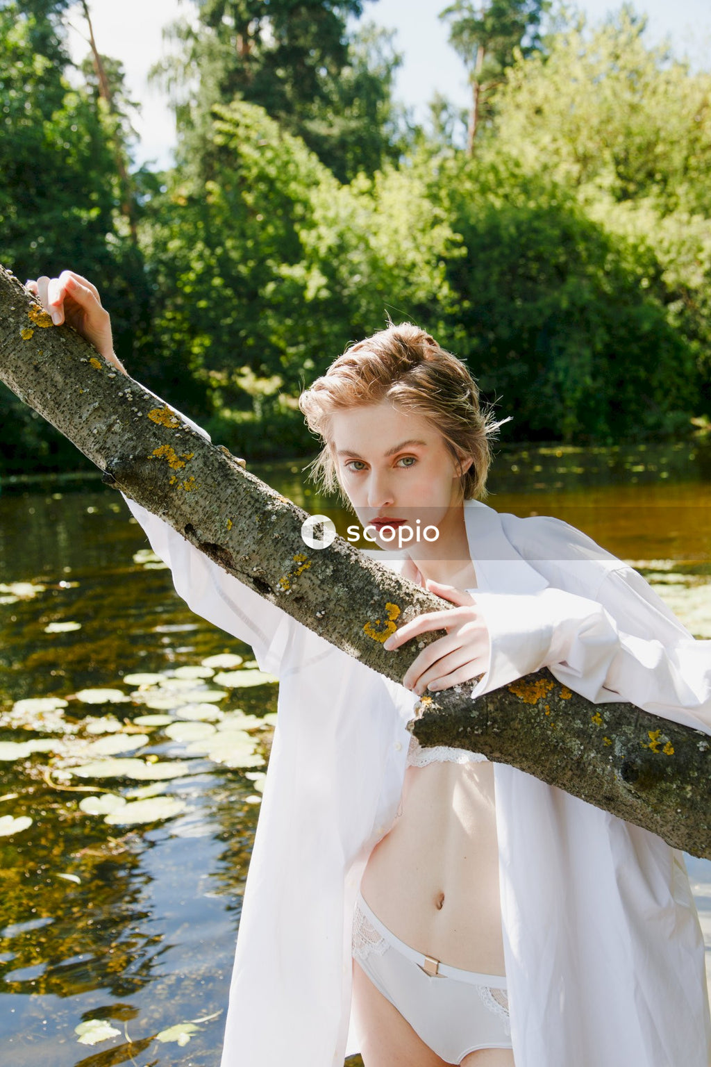 Woman in white dress holding tree branch