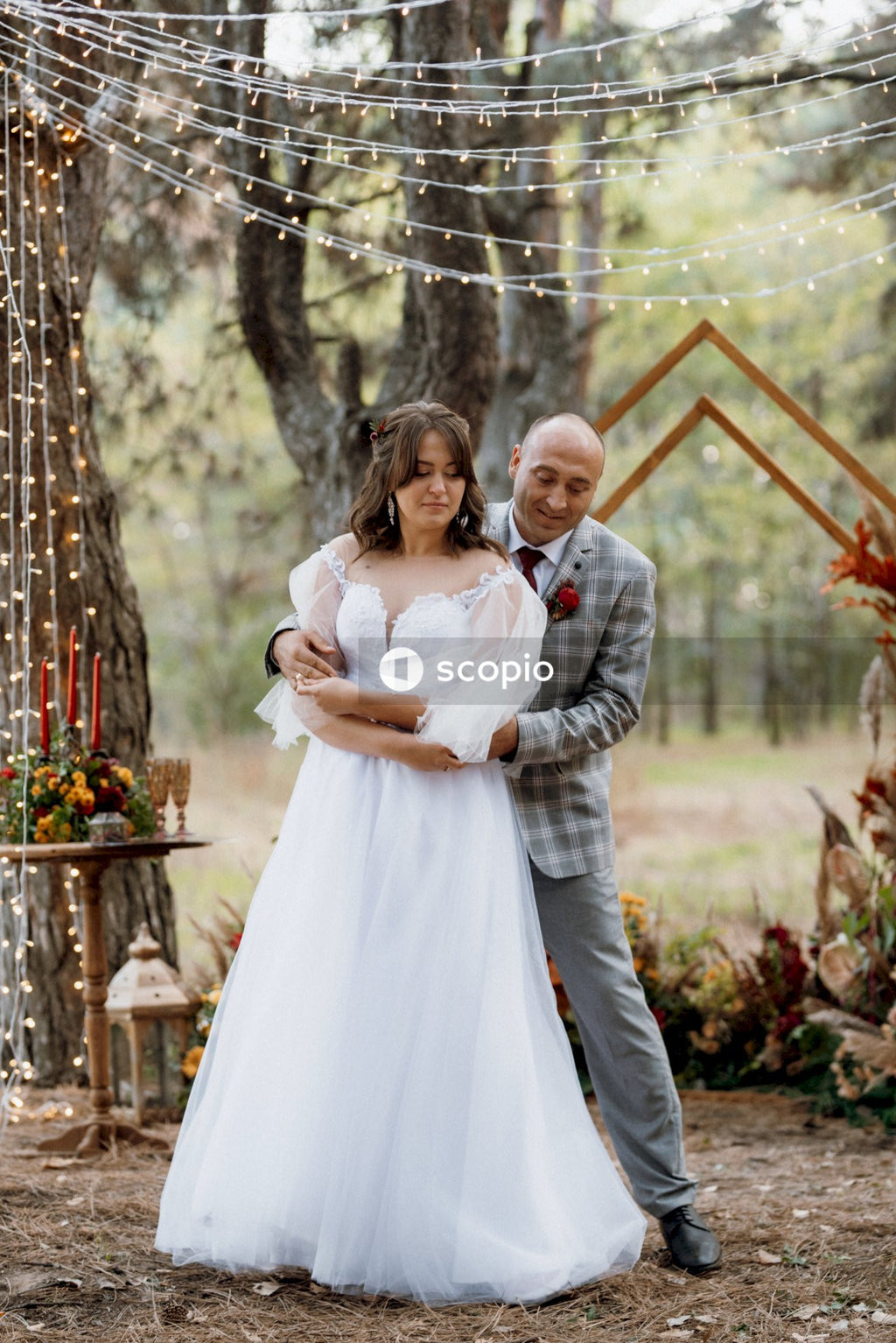 Woman in white dress hugging man in gray dress shirt