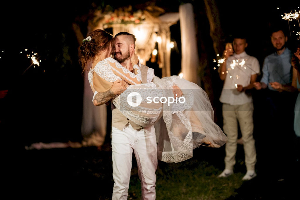 Woman in white dress hugging man in white dress shirt