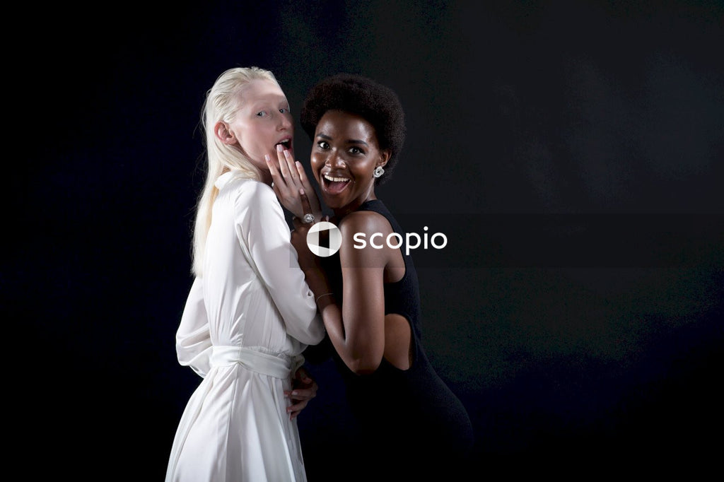 Woman in white dress hugging woman in black tank top