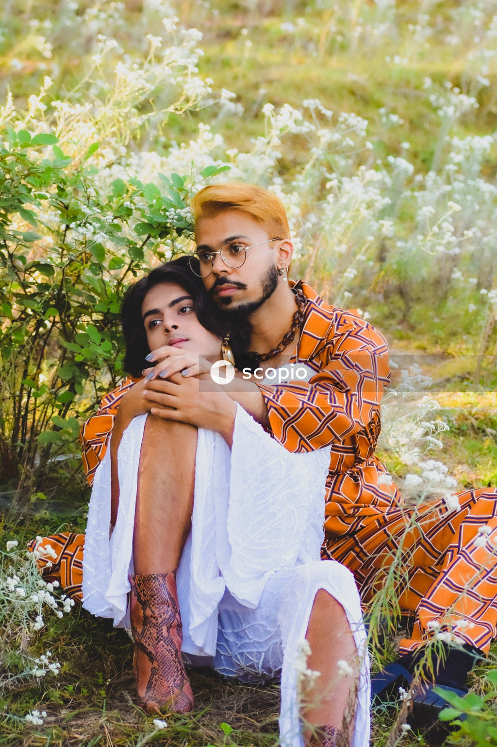 Two genderqueer man in stylish outfits having romantic moments outdoor in the nature