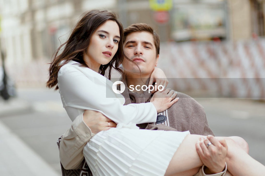 Woman in white dress hugging woman in gray cardigan