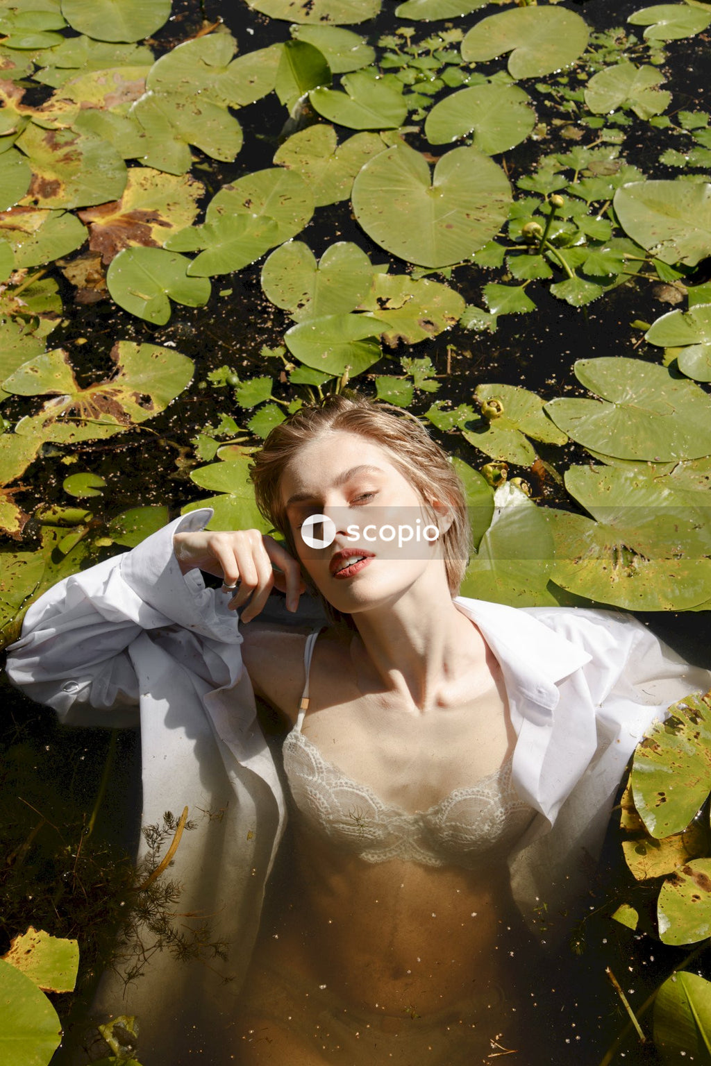 Woman in white dress lying on green grass