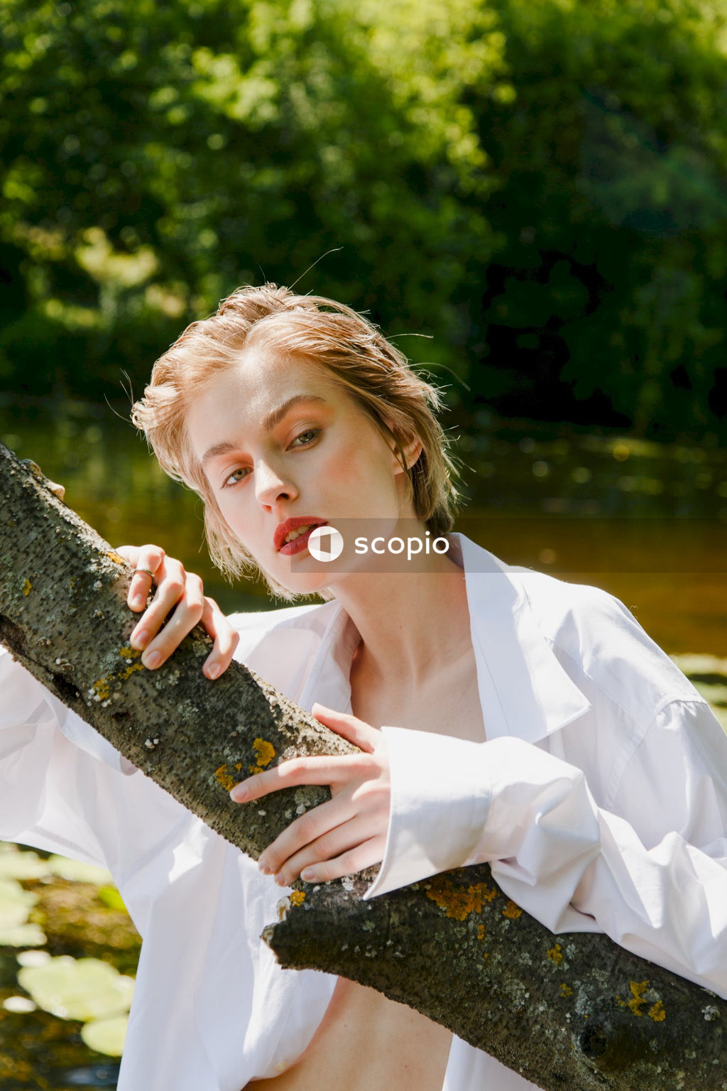Woman in white dress shirt holding black stone