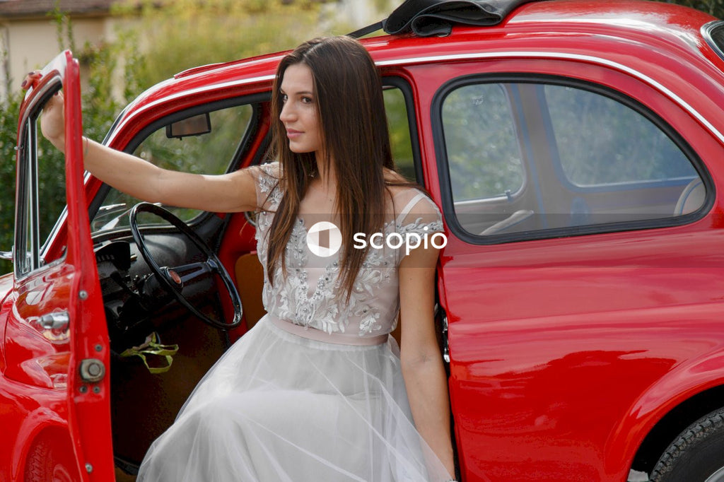 Young married couple doing a photoshoot near small red car