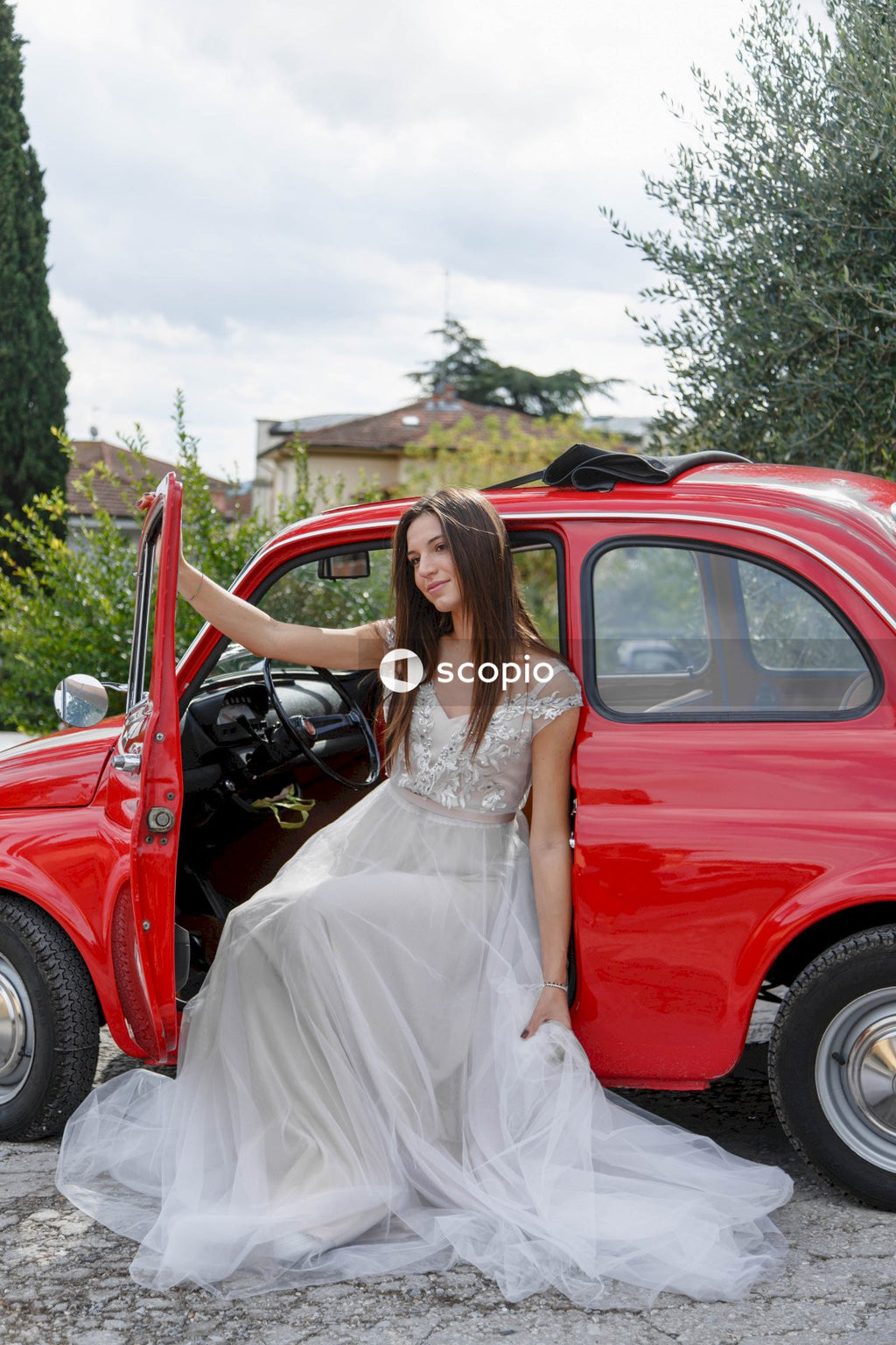Young married couple doing a photoshoot near small red car