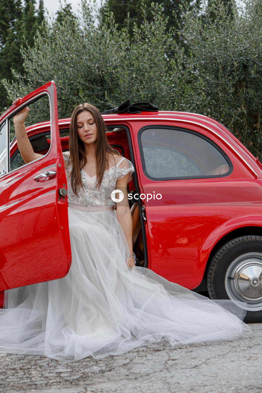 Young married couple doing a photoshoot near small red car