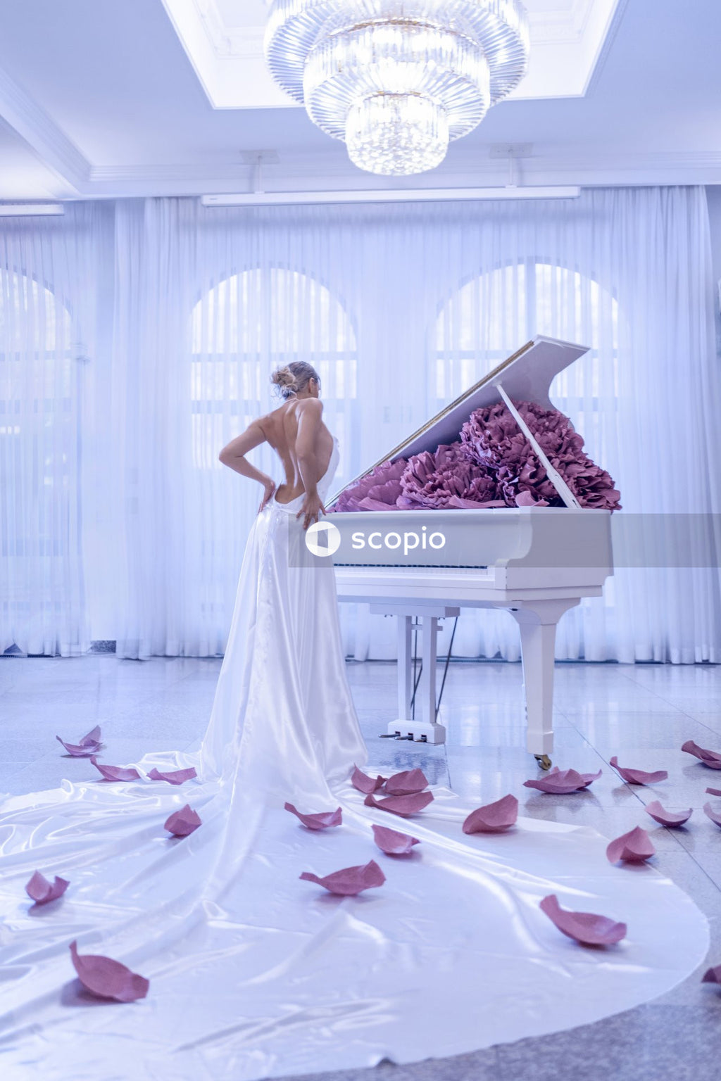 Woman in white dress standing on white and pink floral bed