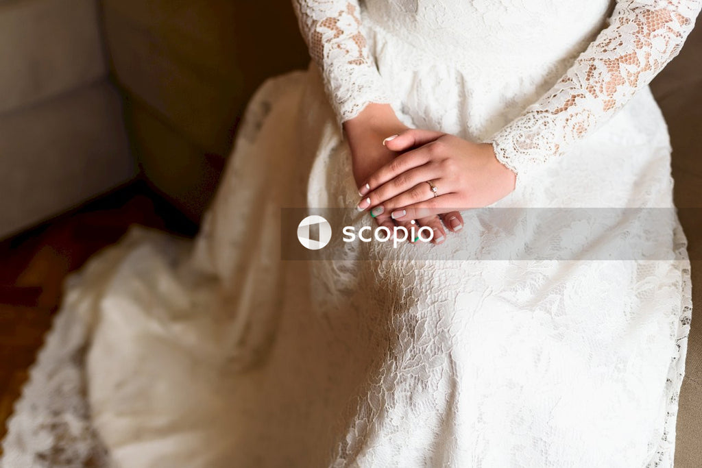 Hands of a woman wearing a bride's dress