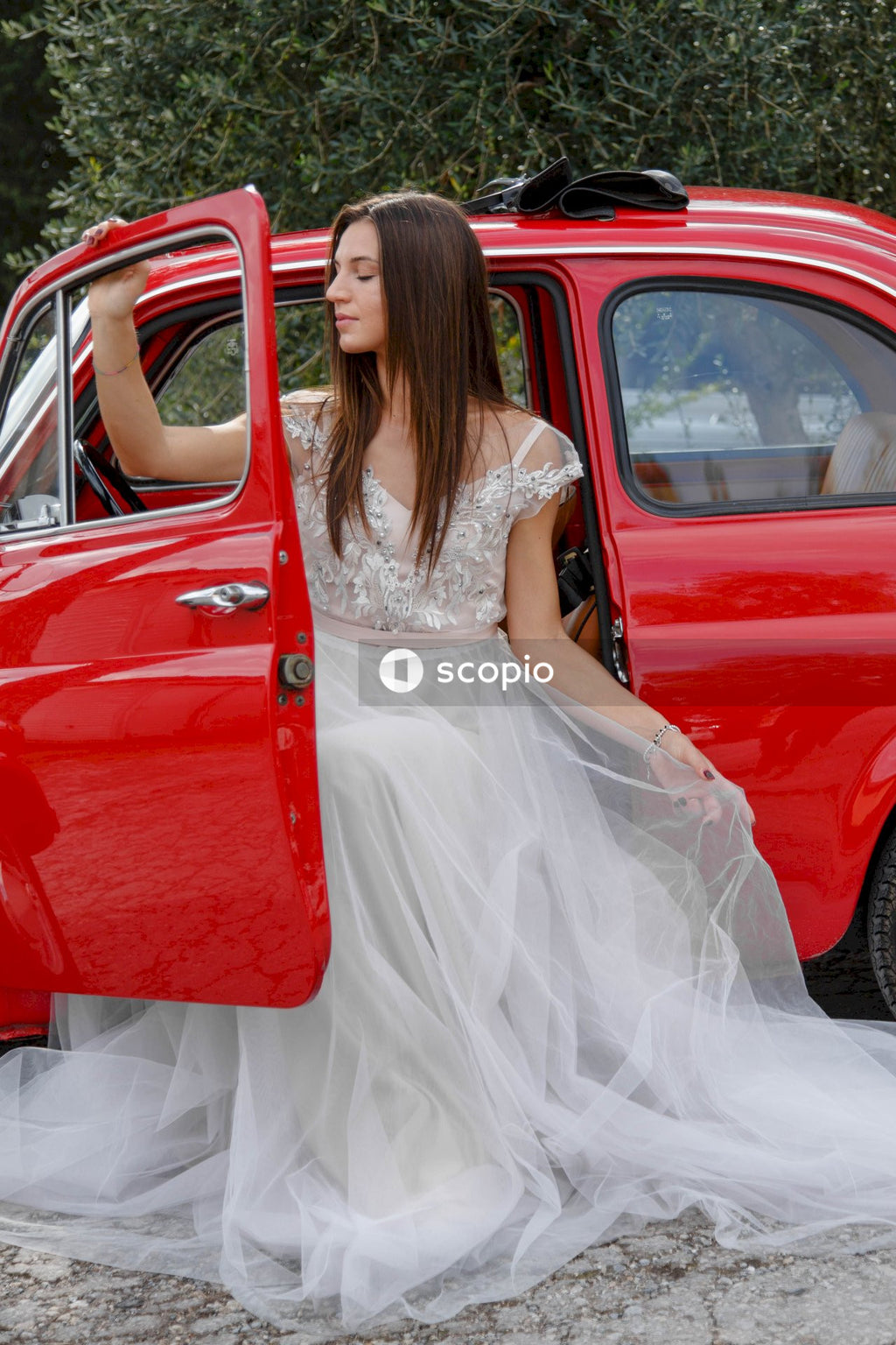 Young married couple doing a photoshoot near small red car