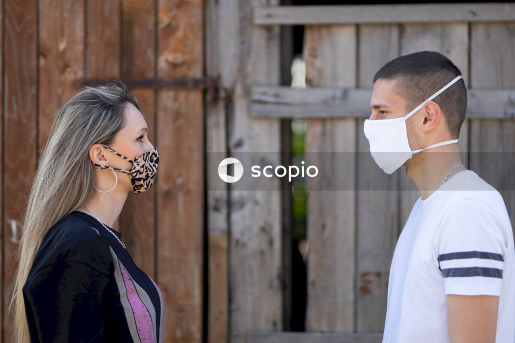 Man and woman with face mask looking at each other outdoor