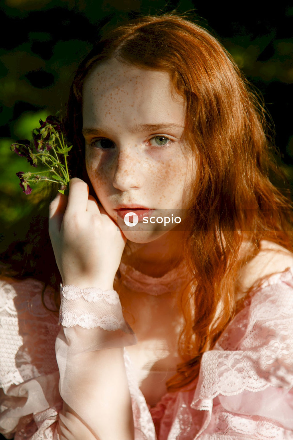 Woman in white lace dress holding green plant