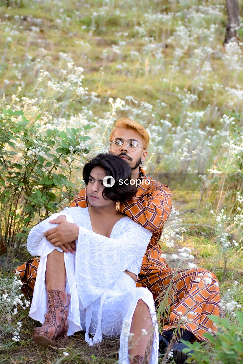 Two genderqueer man in stylish outfits having romantic moments outdoor in the nature