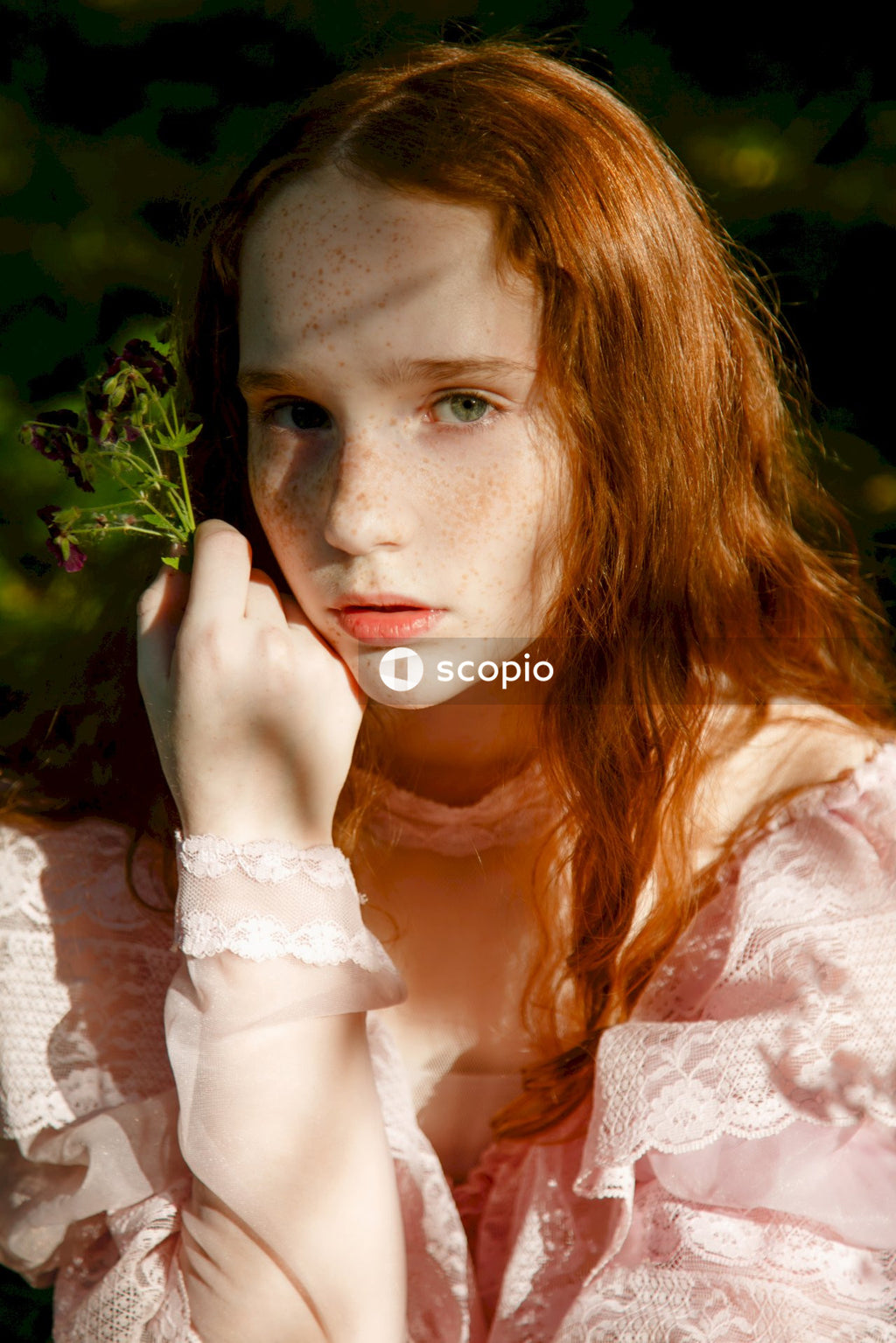 Woman in white lace long sleeve shirt holding her face