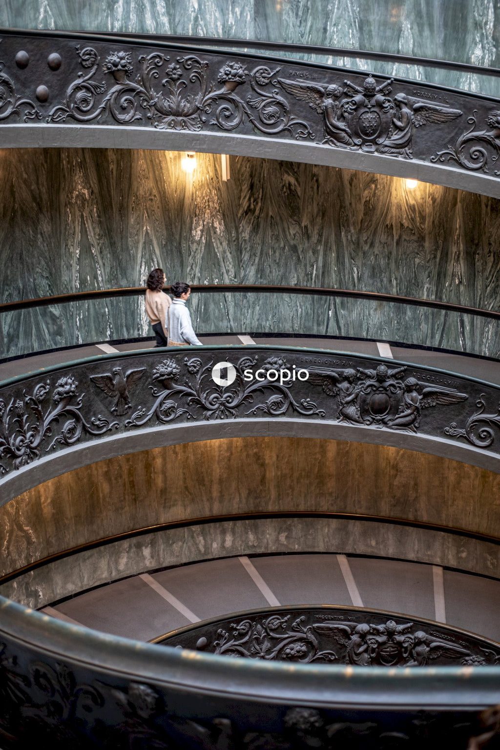 Woman in white long sleeve shirt and black pants standing on spiral staircase