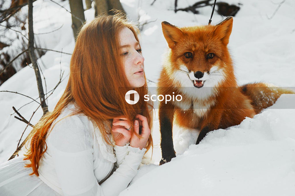Woman in white long sleeve shirt hugging brown dog