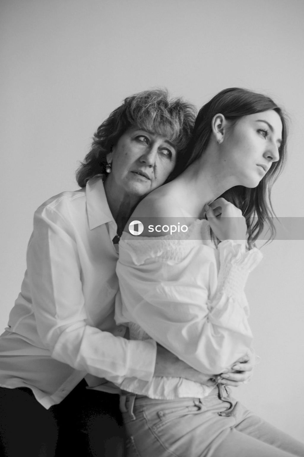 Woman in white long sleeve shirt hugging woman in white long sleeve shirt