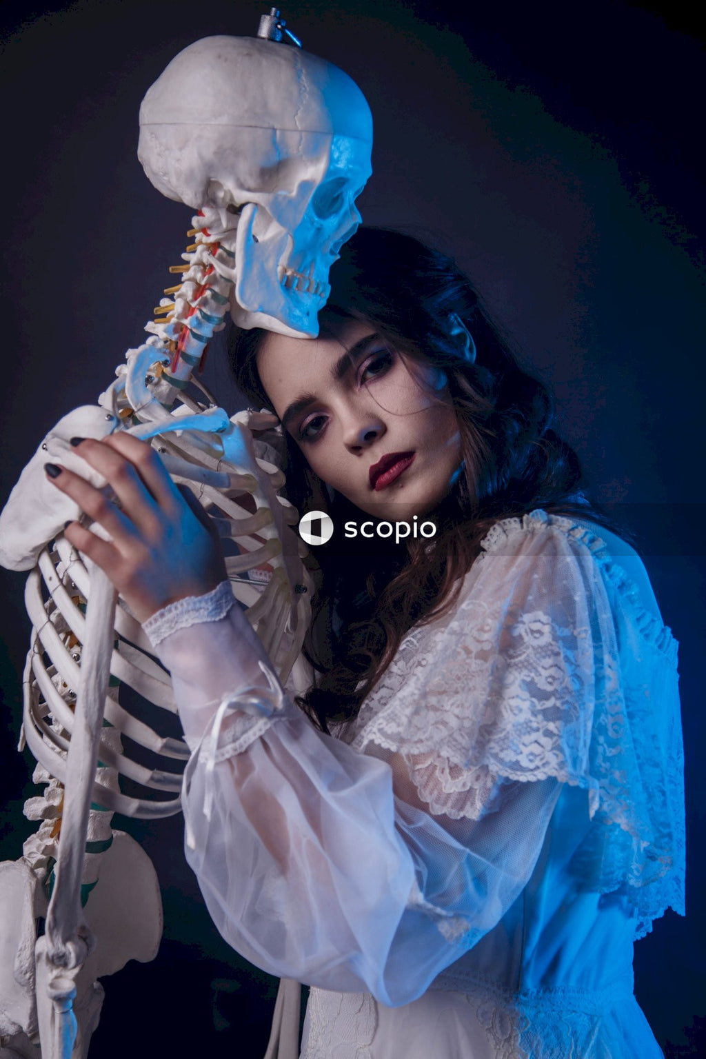 A woman in a white long-sleeve dress hugging the skeleton