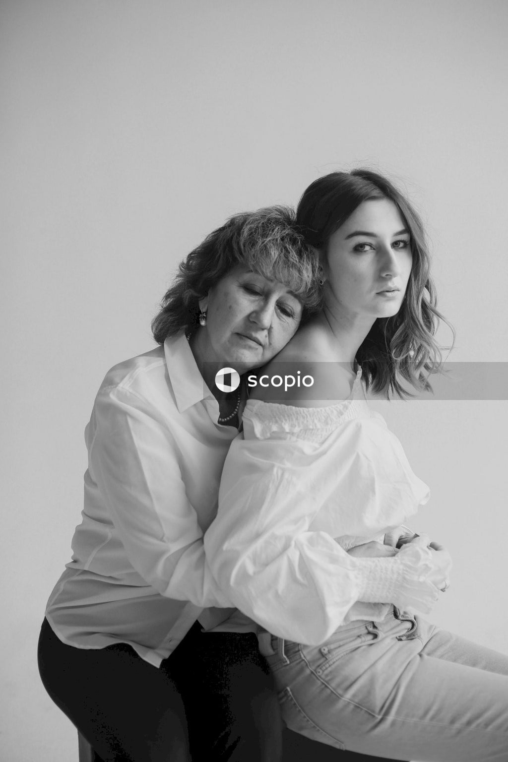 Woman in white off shoulder long sleeve shirt hugging woman in white off shoulder shirt