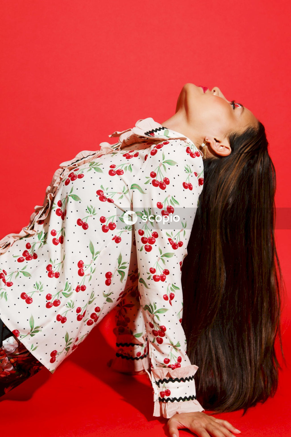 Woman in white red and green floral long sleeve shirt
