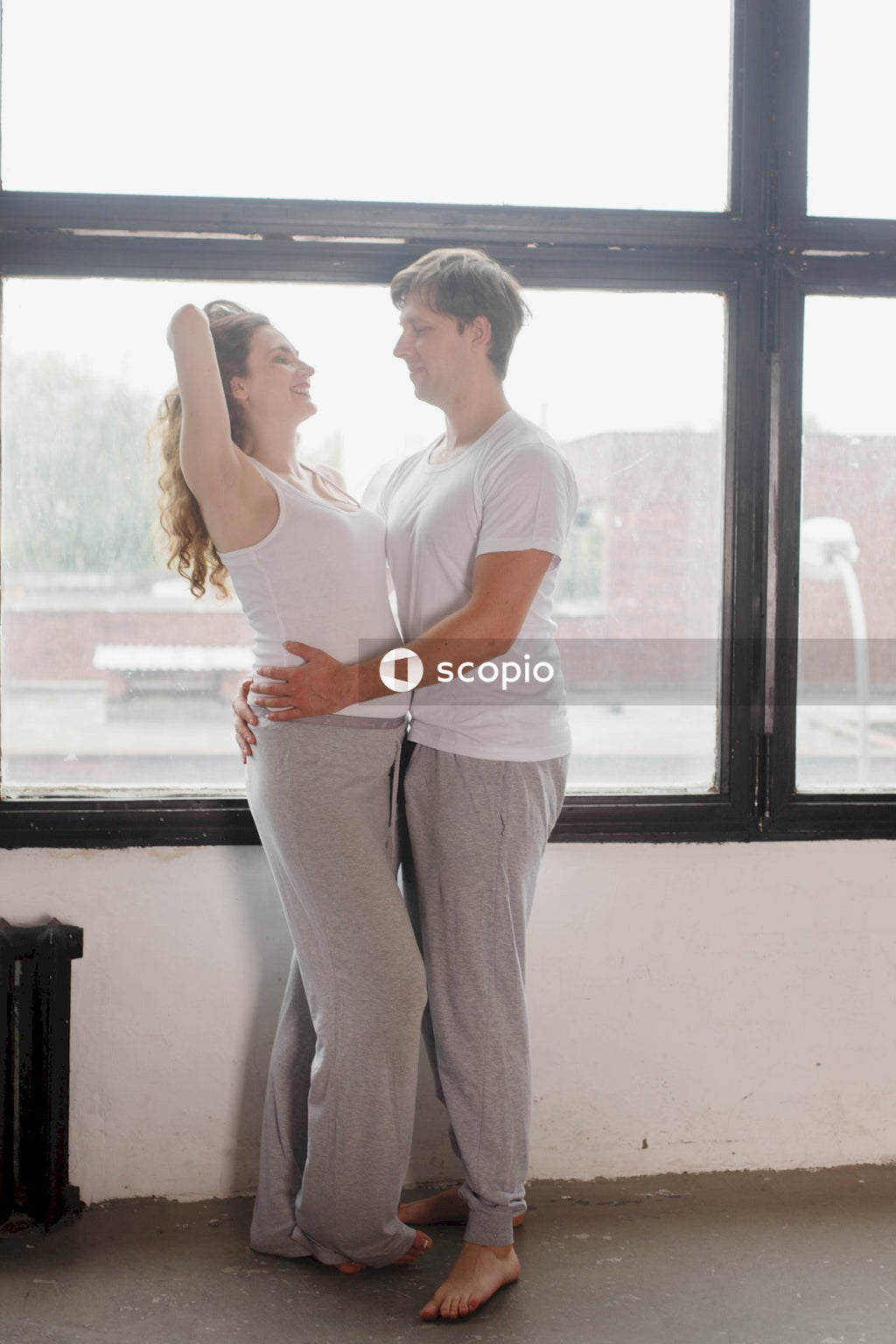 Couple standing beside a glass window