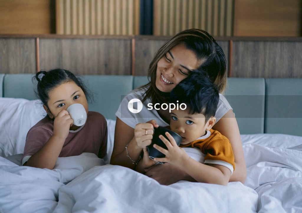 Mother enjoying her children's presence in bedroom in the morning